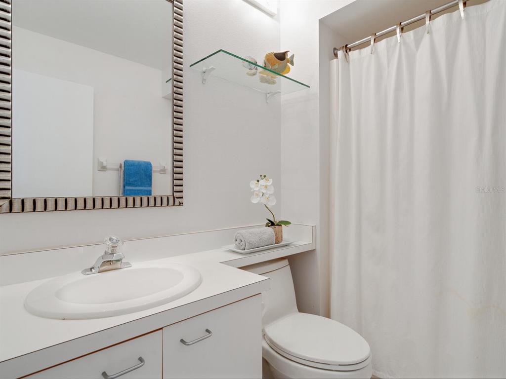 3201 Casey Key Road Nokomis, FL 34275 - Photo 25 of 98 a bathroom with a sink a toilet and shower curtain
