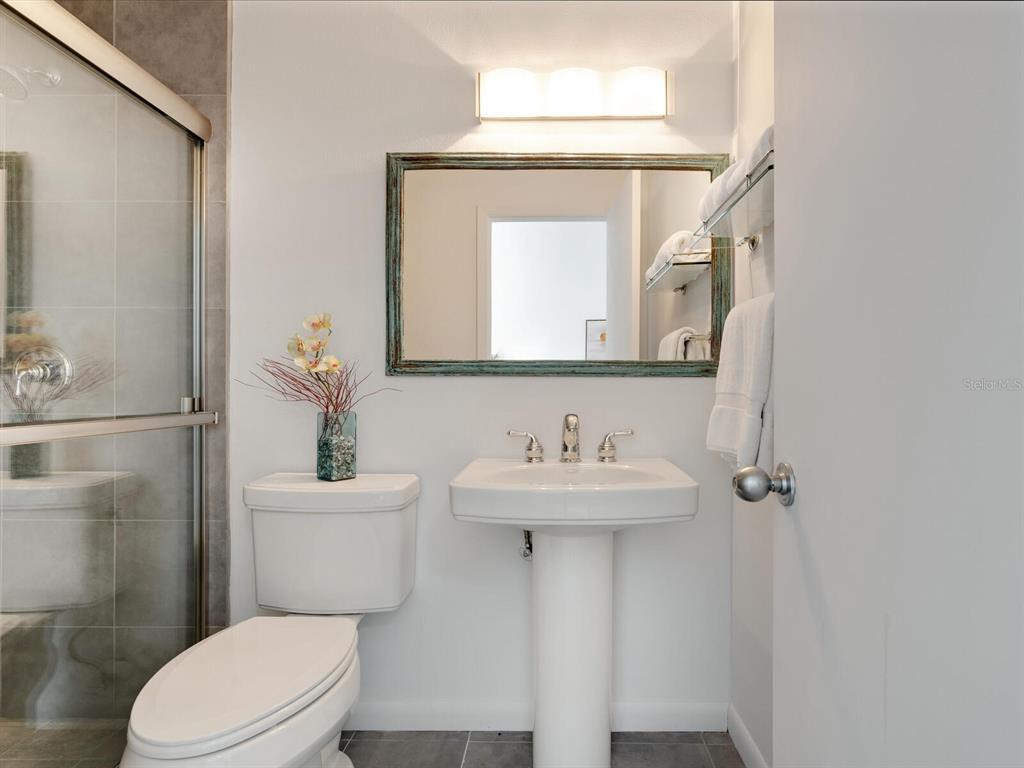 3201 Casey Key Road Nokomis, FL 34275 - Photo 30 of 98 a bathroom with a toilet a sink and mirror