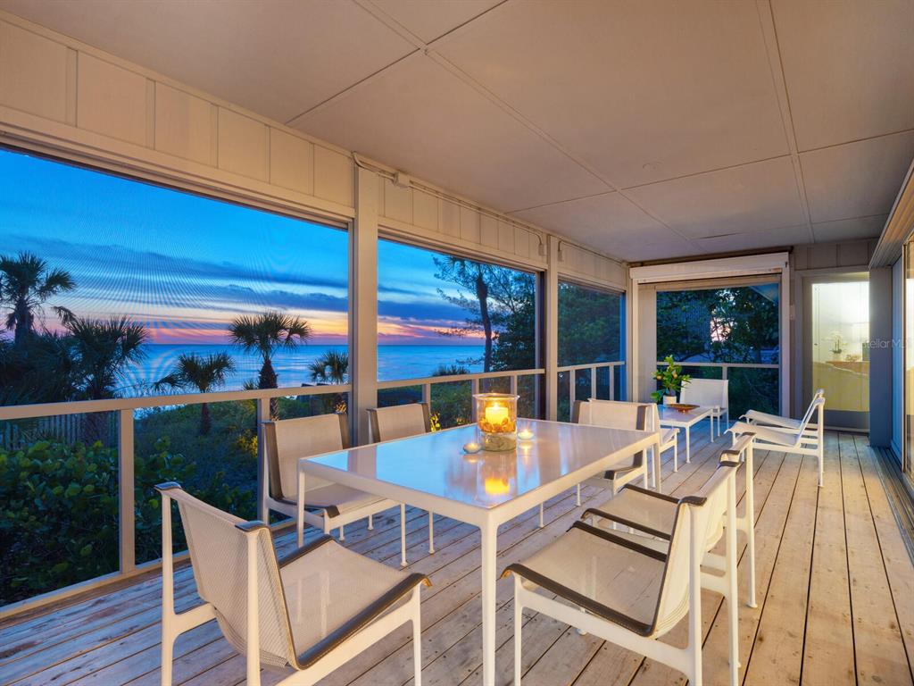 3201 Casey Key Road Nokomis, FL 34275 - Photo 4 of 98 a view of a patio with dining table and chairs with wooden floor