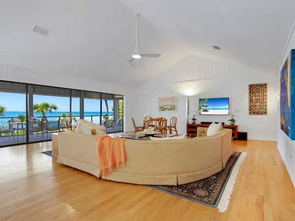 a view of a dining room with furniture water view and wooden floor