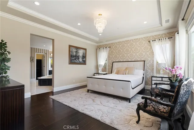 a bedroom with a large bed and a chandelier