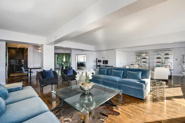 a living room with furniture and a dining table with wooden floor