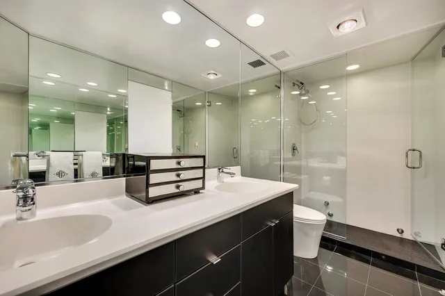 a bathroom with a double vanity sink mirror double and shower