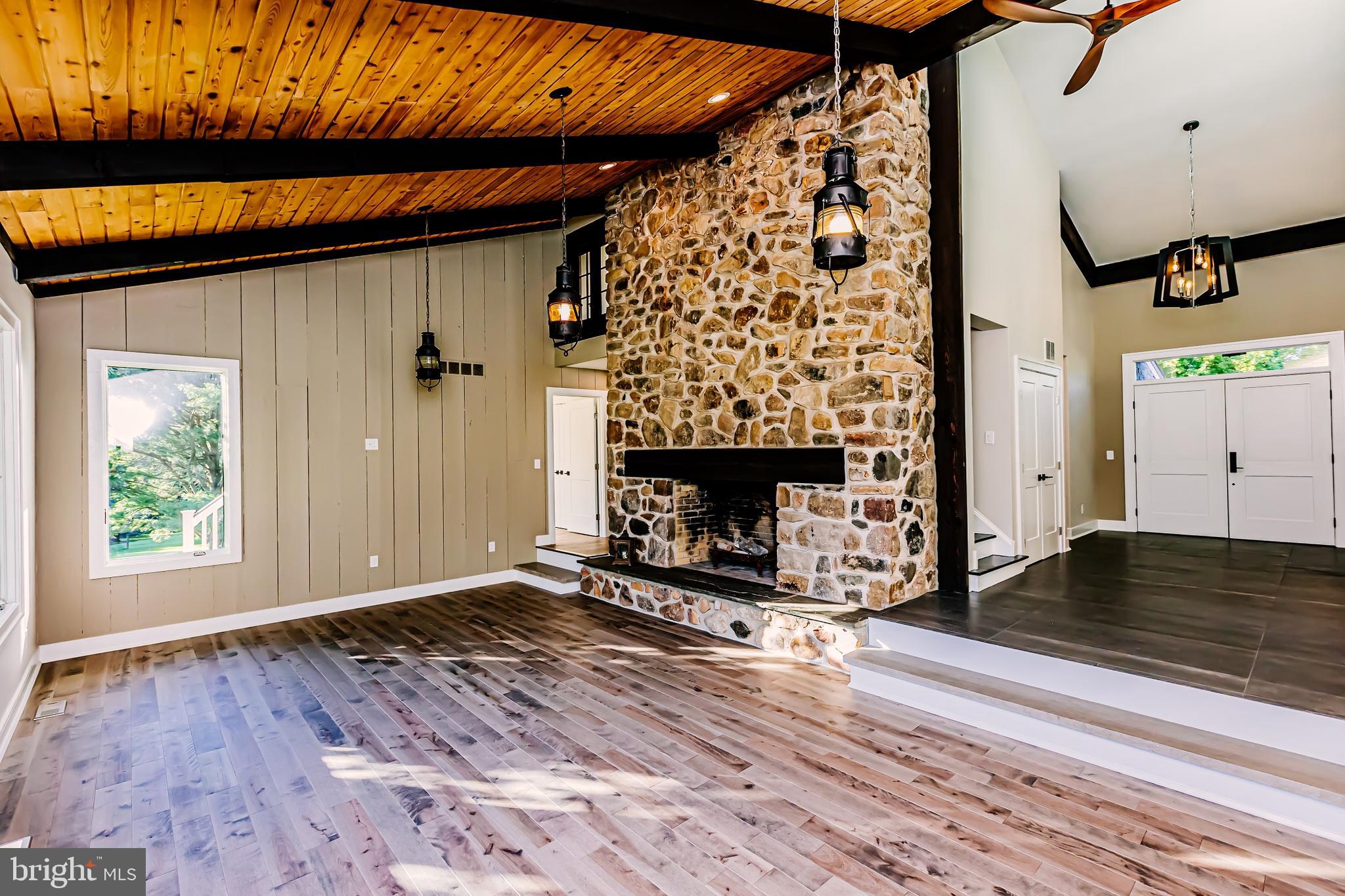 1091 Highland Road Newtown, PA 18940 - Photo 29 of 128 an empty room with wooden floor a fireplace and windows