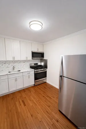 a kitchen with granite countertop a refrigerator and a stove top oven