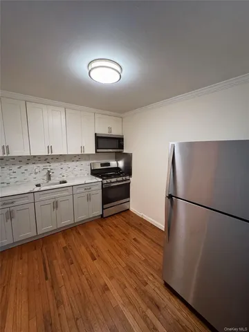 a kitchen with wooden floors and refrigerator