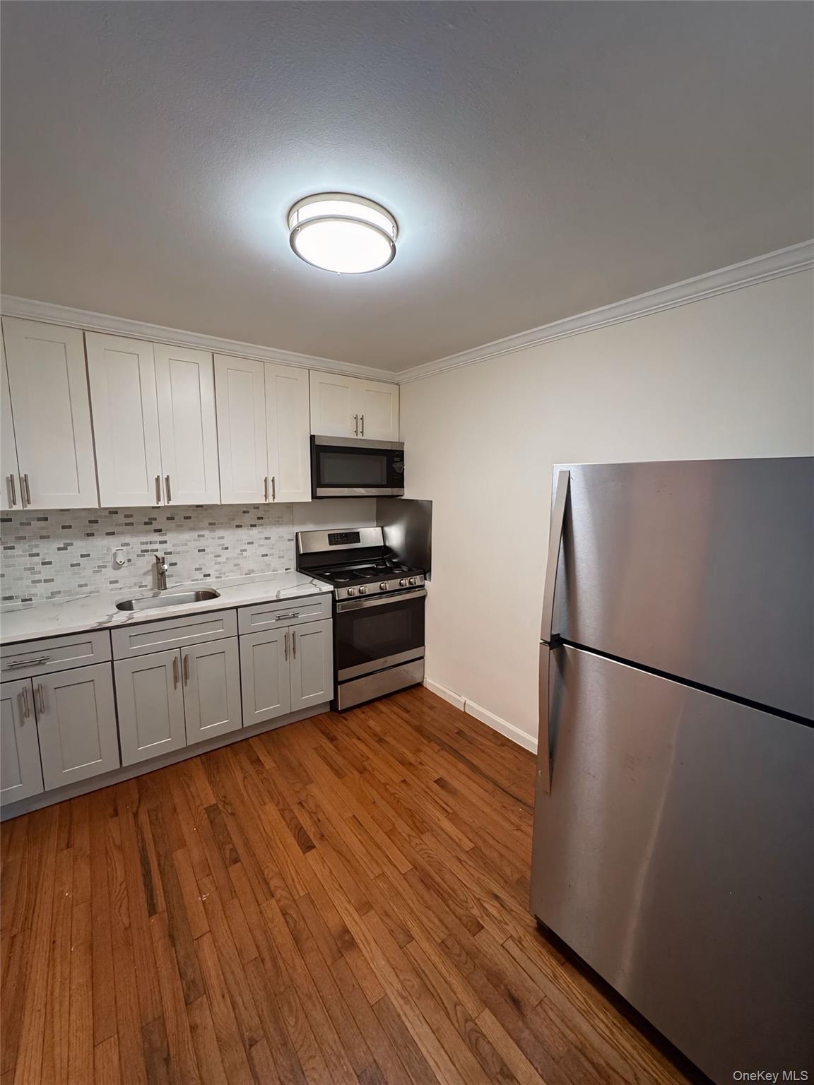 a kitchen with wooden floors and refrigerator