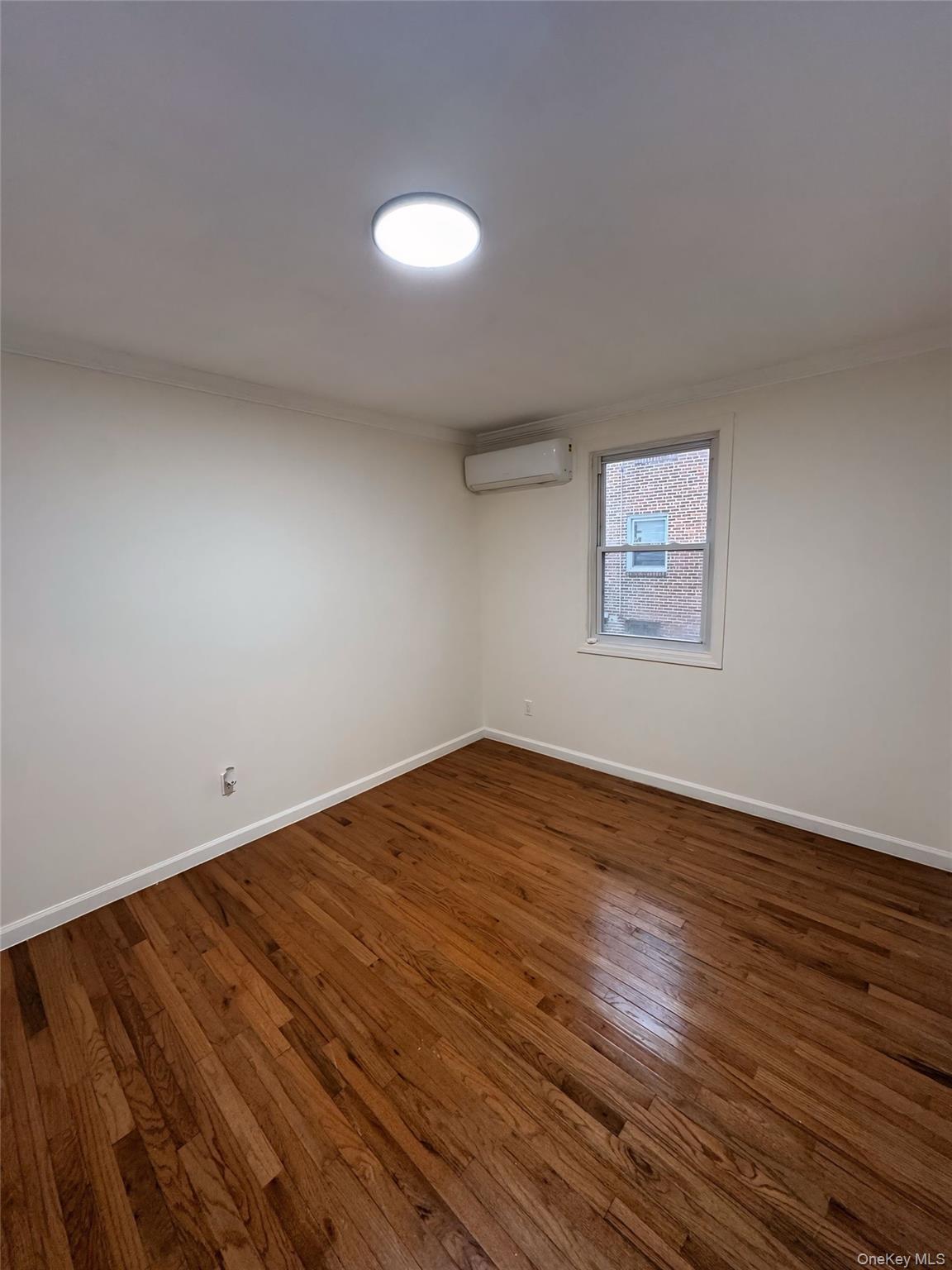 177-16 Leslie Road, Unit 2 Queens, NY 11434 - Photo 2 of 6 a view of empty room with wooden floor and fan