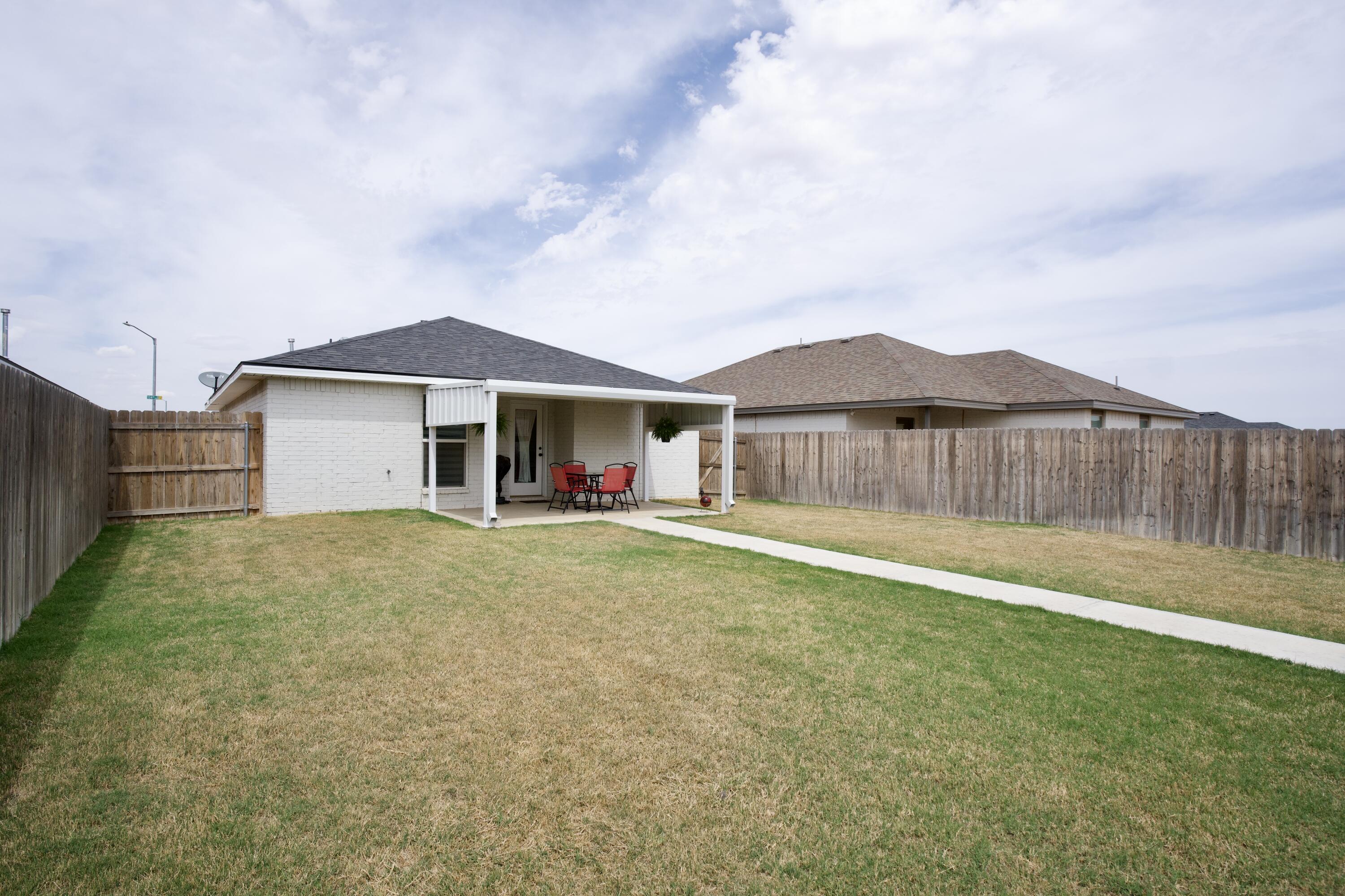 1913 134th Street Lubbock, TX 79423 - Photo 13 of 15 a view of a house with a yard and wooden fence