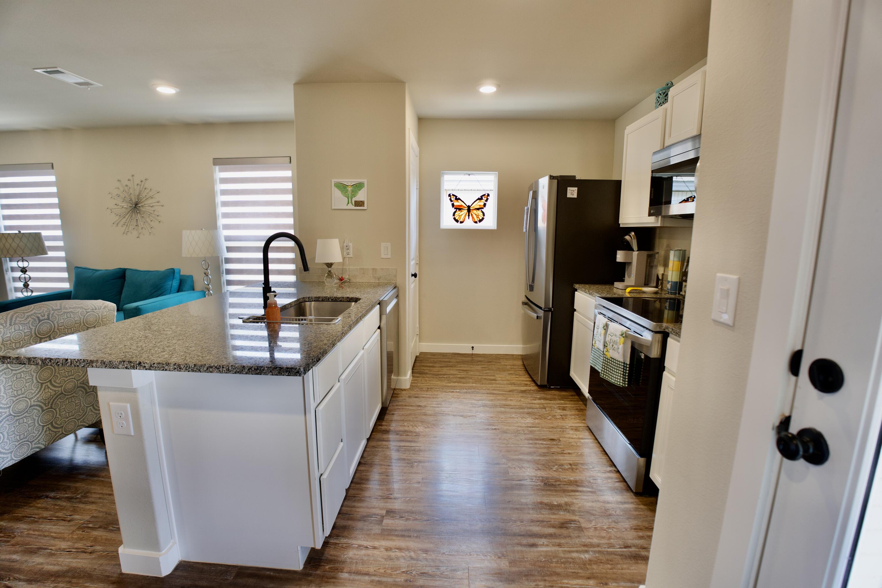 1913 134th Street Lubbock, TX 79423 - Photo 5 of 15 a kitchen with stainless steel appliances granite countertop a sink a counter top space cabinets and a window