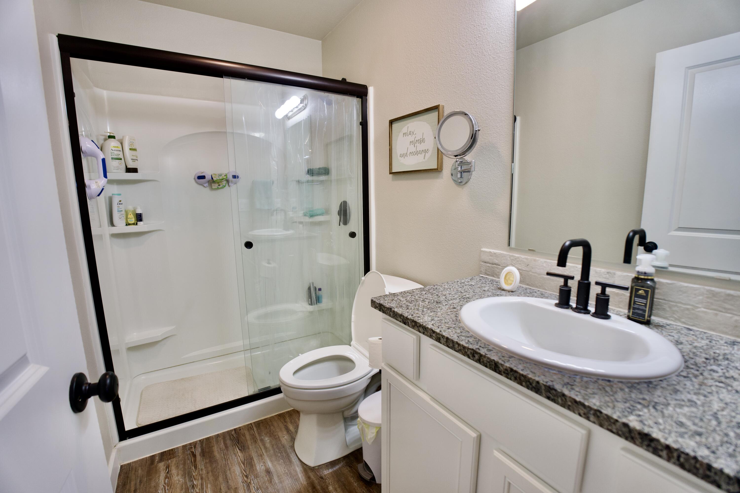 1913 134th Street Lubbock, TX 79423 - Photo 9 of 15 a bathroom with a granite countertop sink toilet and shower a mirror