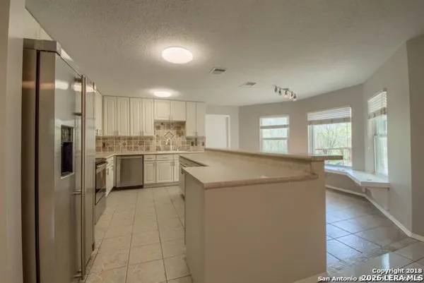 a kitchen with a refrigerator a sink and cabinets