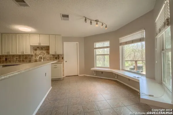 a large white kitchen with a large window