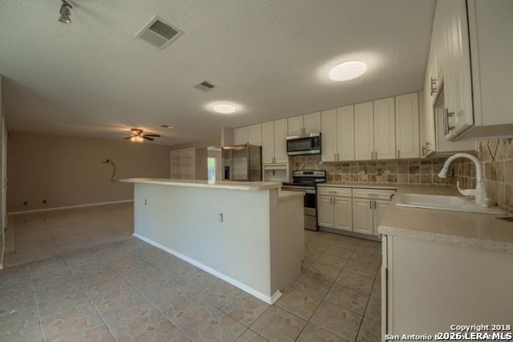 6911 Ridge Pl Street San Antonio, TX 78250 - Photo 13 of 22 a kitchen with refrigerator cabinets and a sink