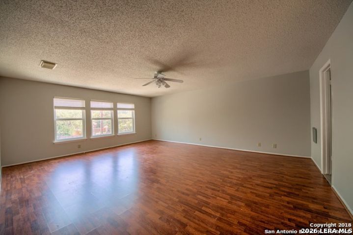 6911 Ridge Pl Street San Antonio, TX 78250 - Photo 15 of 22 an empty room with wooden floor and windows