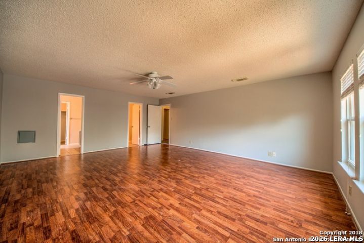 6911 Ridge Pl Street San Antonio, TX 78250 - Photo 16 of 22 wooden floor in an empty room with a window