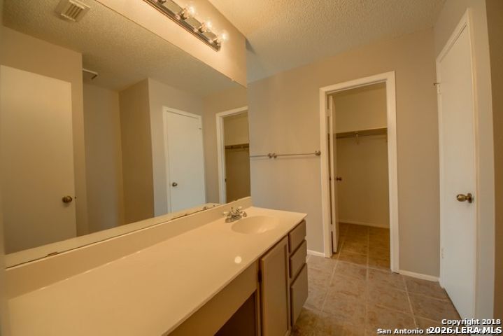 6911 Ridge Pl Street San Antonio, TX 78250 - Photo 18 of 22 a room with a bed and a view of bathroom