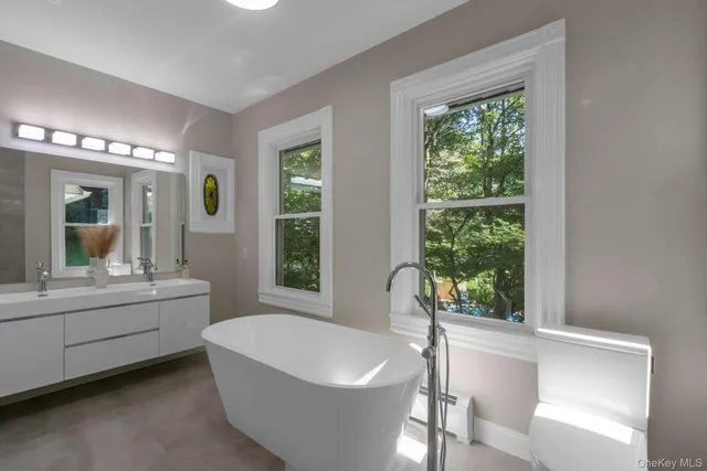 a bathroom with a white tub sitting next to a large window
