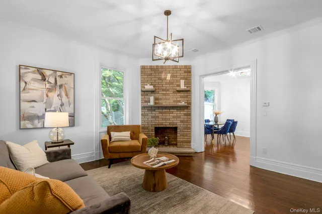 a living room with furniture a fireplace and a chandelier