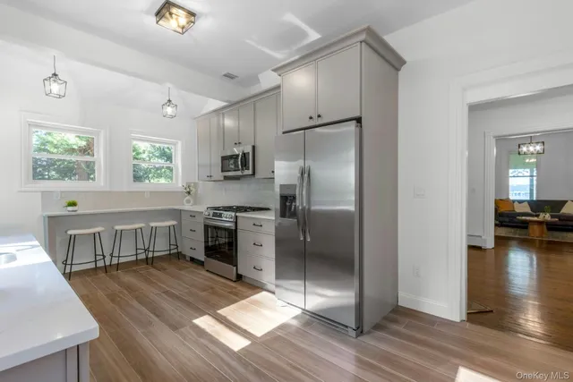 a kitchen with kitchen island a counter top space a sink stainless steel appliances and cabinets