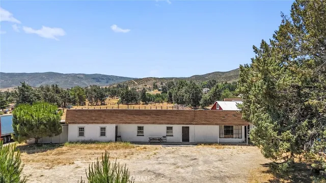 a view of house with a yard and mountain view in back
