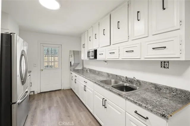 a kitchen with granite countertop a white stove top oven and refrigerator