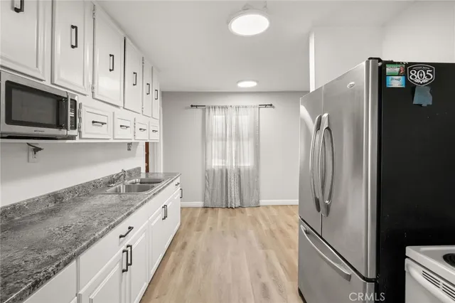 a kitchen with stainless steel appliances granite countertop a refrigerator and a stove top oven