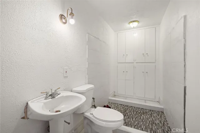 a bathroom with a sink a toilet and shower