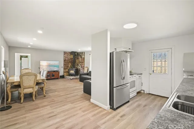 a kitchen with stainless steel appliances granite countertop a refrigerator and a stove top oven