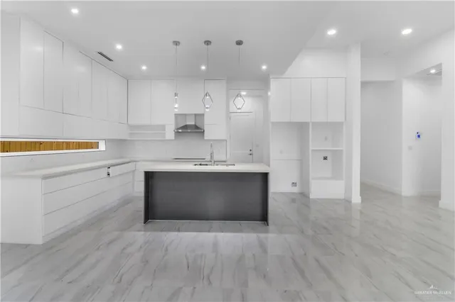 a large kitchen with a lot of counter space and wooden floor