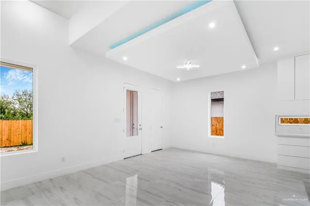 an empty room with windows and mirror