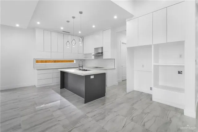 a kitchen with kitchen island a sink stainless steel appliances and cabinets