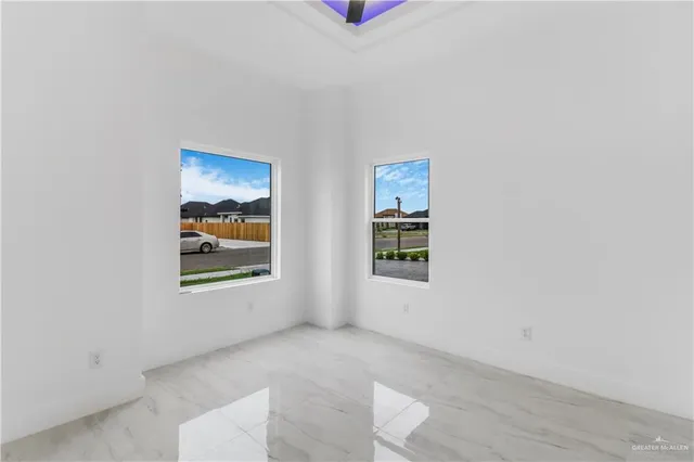 an empty room with windows and fan