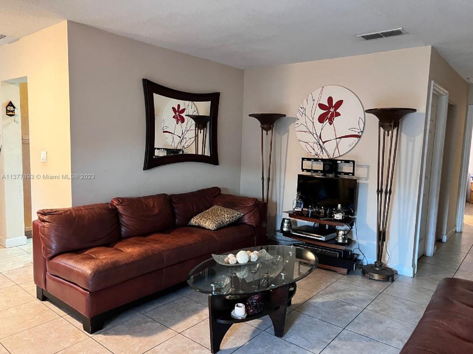 15465 Southwest 80th Street, Unit 2014 Miami, FL 33193 - Photo 14 of 23 a living room with furniture a flat screen tv and a window