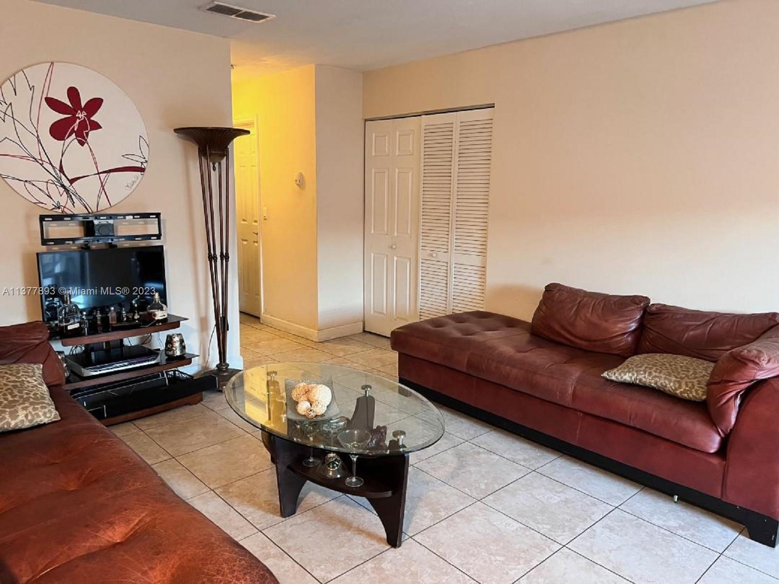15465 Southwest 80th Street, Unit 2014 Miami, FL 33193 - Photo 2 of 23 a living room with furniture and a flat screen tv