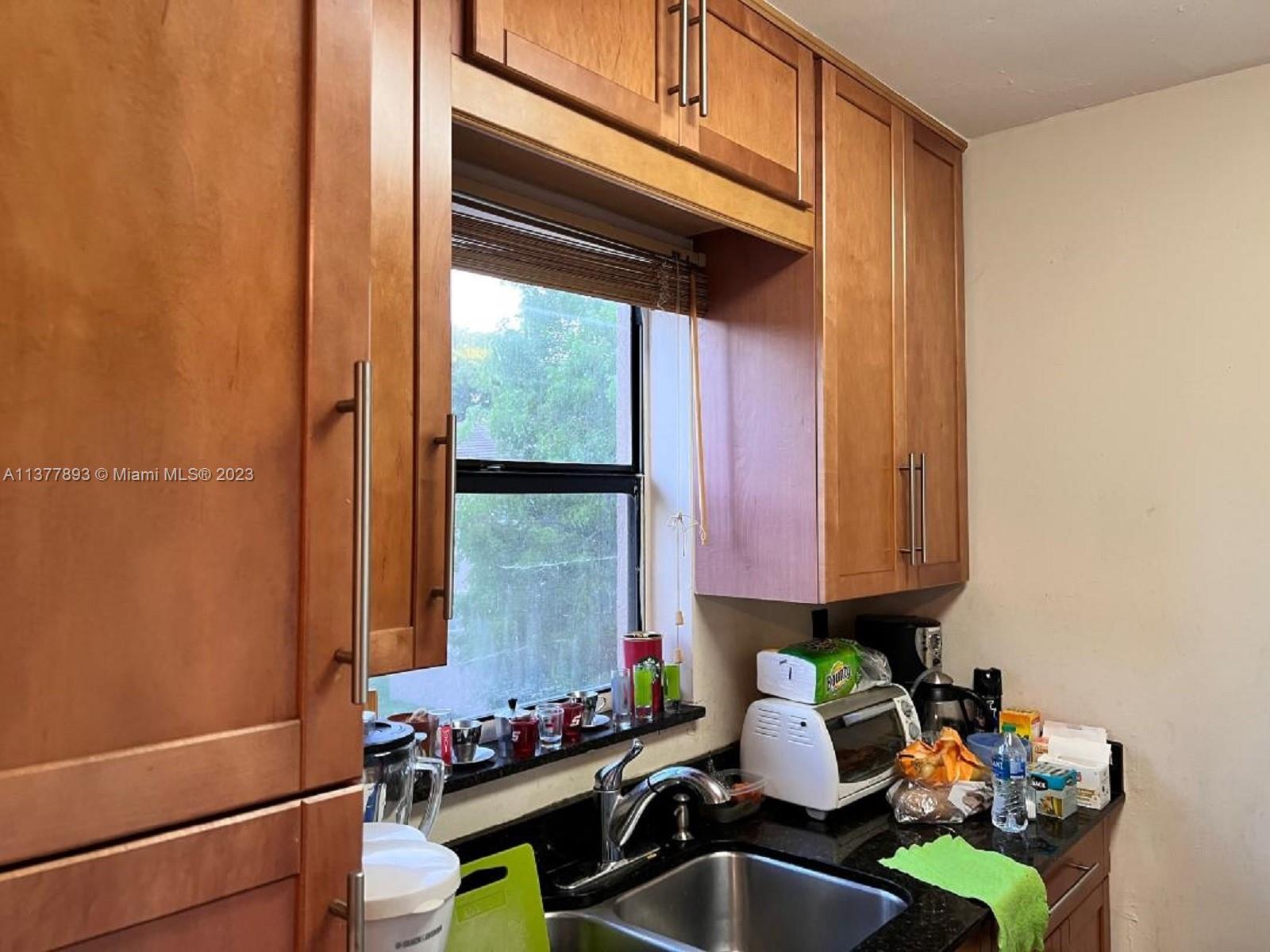 15465 Southwest 80th Street, Unit 2014 Miami, FL 33193 - Photo 5 of 23 a kitchen with a sink cabinets and a window