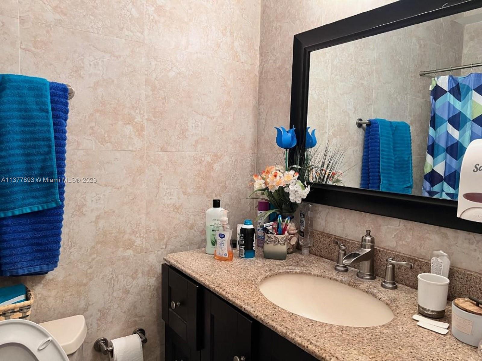15465 Southwest 80th Street, Unit 2014 Miami, FL 33193 - Photo 8 of 23 a bathroom with a granite countertop sink and a mirror
