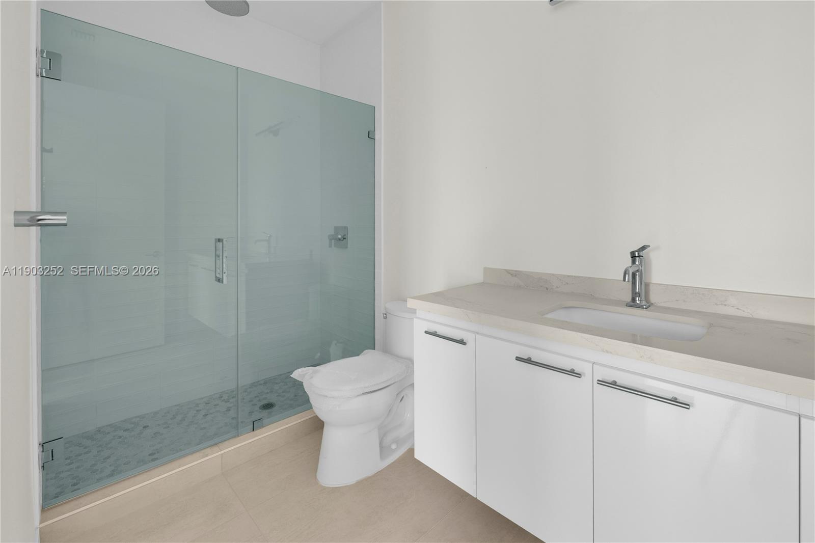 530 Southwest 11th Avenue, Unit 103 Miami, FL 33130 - Photo 7 of 18 a bathroom with a granite countertop sink a toilet and shower