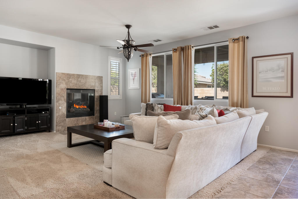 83460 Lone Star Road Indio, CA 92203 - Photo 11 of 40 a living room with furniture a flat screen tv and a fireplace