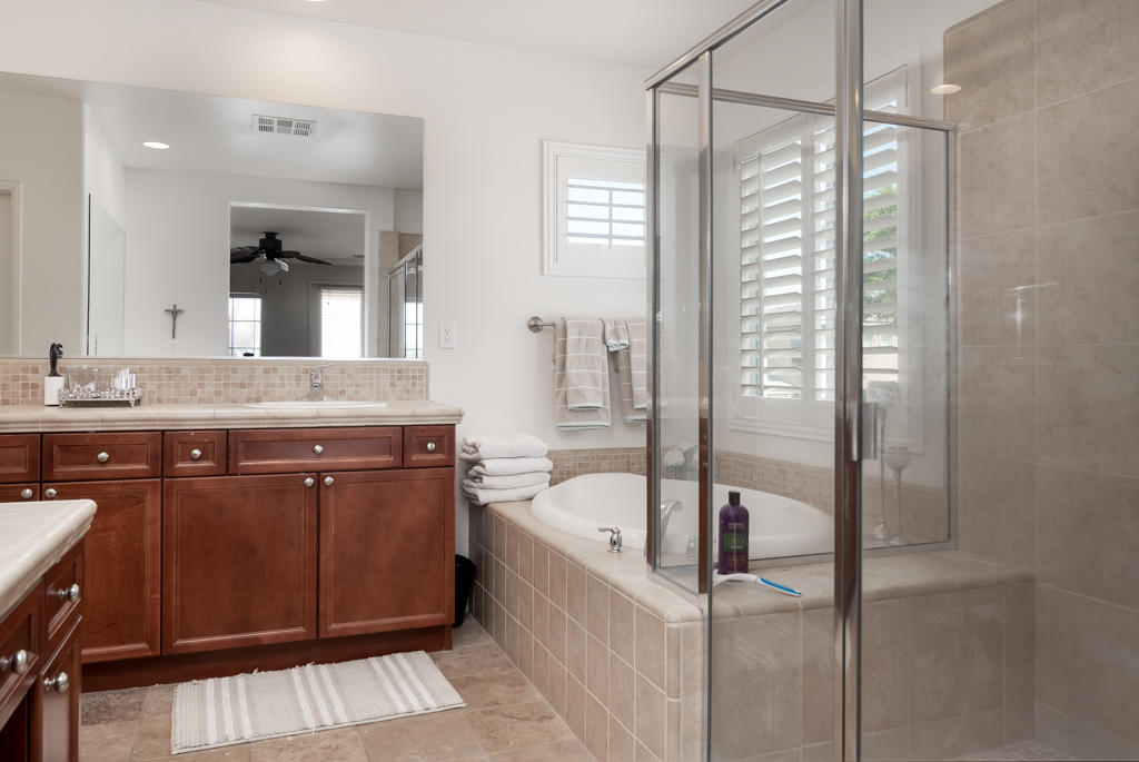 83460 Lone Star Road Indio, CA 92203 - Photo 22 of 40 a bathroom with a granite countertop sink a mirror a bathtub and next to a window