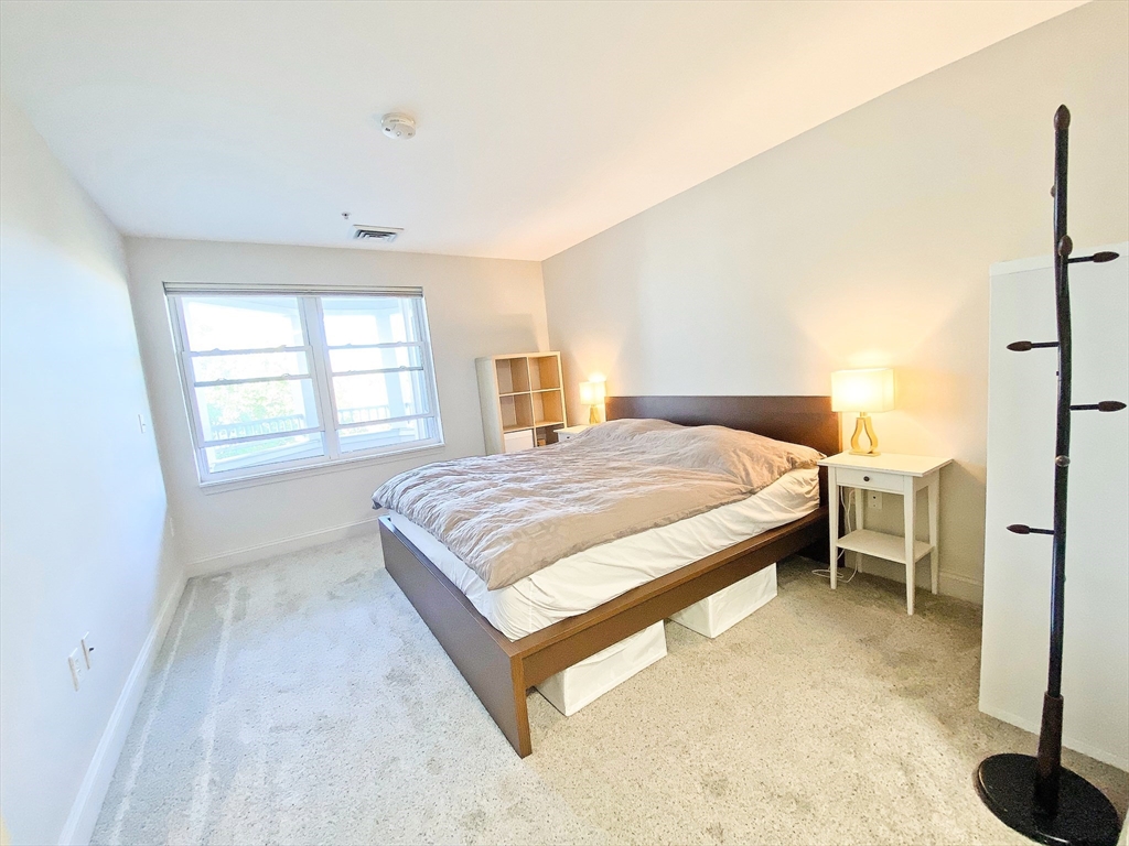 318 Rindge Avenue, Unit 405 Cambridge, MA 02140 - Photo 13 of 25 a spacious bedroom with a bed and a window