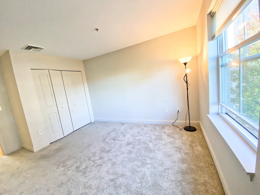 318 Rindge Avenue, Unit 405 Cambridge, MA 02140 - Photo 19 of 25 a view of an empty room with a window