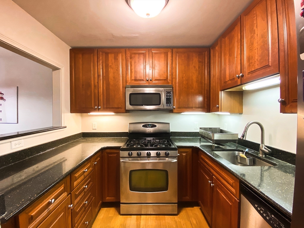 318 Rindge Avenue, Unit 405 Cambridge, MA 02140 - Photo 4 of 25 a kitchen with a sink a stove and cabinets