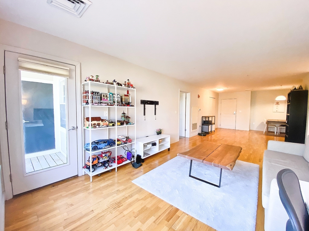 318 Rindge Avenue, Unit 405 Cambridge, MA 02140 - Photo 8 of 25 a living room with furniture and a wooden floor