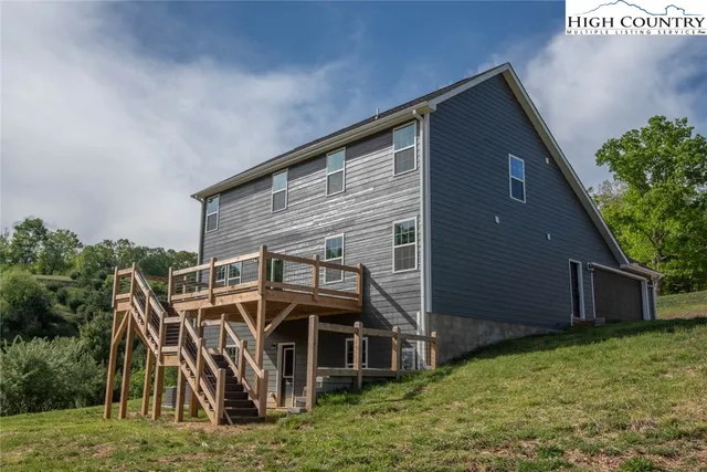 a view of a house with a big yard and large trees