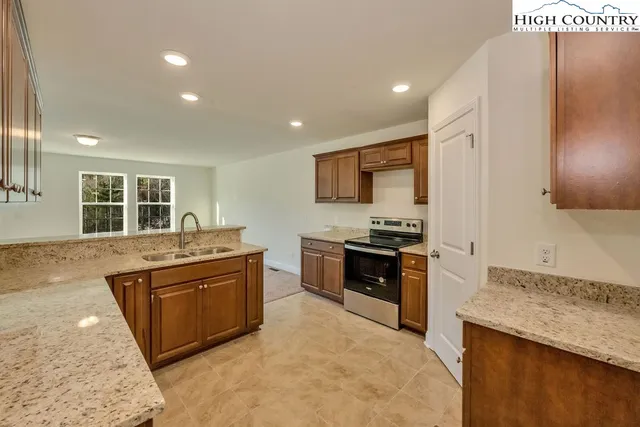 a kitchen with stainless steel appliances granite countertop a sink stove and cabinets