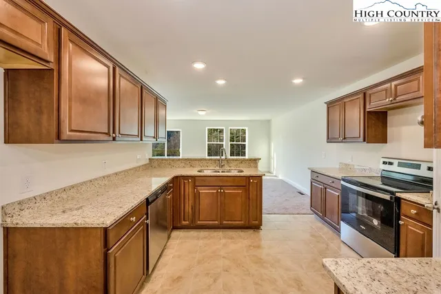 a kitchen with stainless steel appliances granite countertop a sink and dishwasher with wooden cabinets