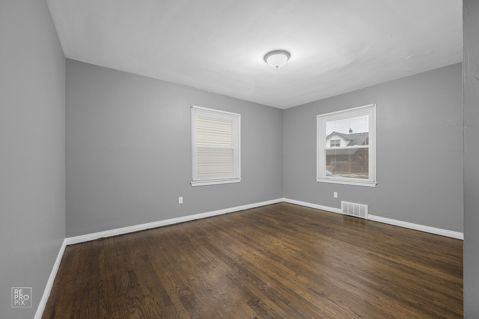 342 Pulaski Road Calumet City, IL 60409 - Photo 7 of 10 an empty room with wooden floor and windows