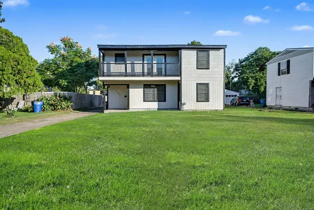 a front view of a house with a yard and trees