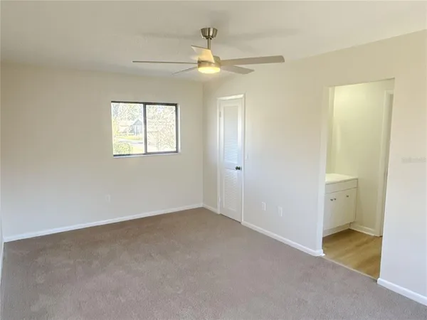an empty room with a ceiling fan and a window